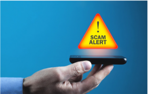 man's hand holding a mobile phone with Scam Alert! icon above it.