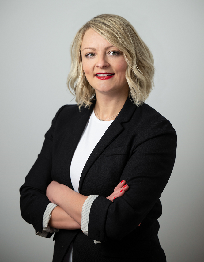 An image of Anya K. Vitikova, the Bank's Vice President, Residential Lending Manager, standing in front of a grey background, smiling with her arms crossed.