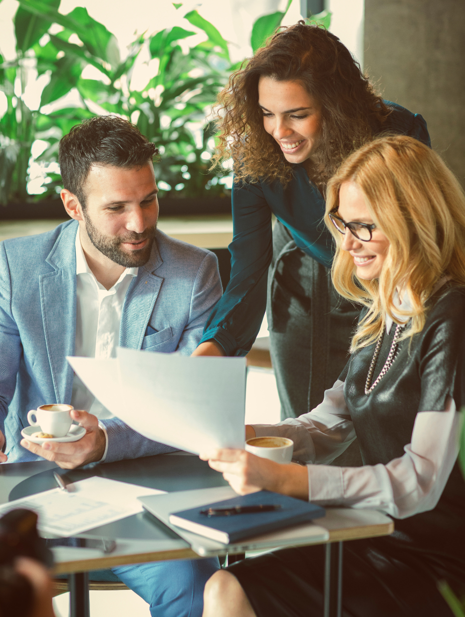 A man and 2 women looking at a document together.